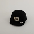 Dettaglio del cappellino nero per neonati con visiera morbida e toppa in pelle a topo - 48-50cm 1-2 Anni / Nero