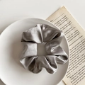 Elegant silver grey satin scrunchie with smooth pleated texture on a white decorative plate - 1076F Silver Gray Satin Scrunchie