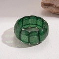 Makroansicht des breiten grünen Acrylarmbands mit glitzernden Pailletten und eckigen Gliedern - Armband-Grün (Goldener Glitzer)