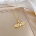 Detailopname van gouden engelenvleugel ketting met hartvormige zirkoon op zijden stof - Roestvrij staal/Koper/Zirconia / F227 Roestvrijstalen Ketting Koperen Micro-pave Hanger / Goud
