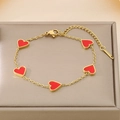 Detalle de la pulsera de titanio dorada con cinco corazones rojos sobre un joyero - Rojo (KB187179-BI)