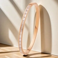 Rose gold stainless steel bangle with rectangular zircon stones on a warm studio background - Baguette Stone (44-E-2) / Rose Gold