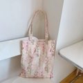 Detalle de bolsa de lona con flores rosas mostrando la etiqueta tejida y textura de algodón - Estampado Floral Rosa Suave