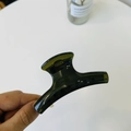 Detail of a deep olive green translucent shark hair claw clip held by hand for size scale - Medium-8cm / Translucent Grey Green