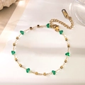 Dettaglio di un bracciale in acciaio inossidabile placcato oro 18k con cristalli verdi - Bracciale A Catena A Cubo Con Pietra Verde / Oro