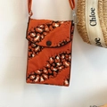 Detalle del bolso bandolera de punto naranja con estampado blanco y negro y cierre hebilla - Cebra Naranja