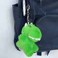 Simpatico portachiavi di peluche a forma di dinosauro verde appeso a uno zaino blu - Dragone Addormentato - Verde Chiaro