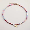 Detail of colorful beaded necklace with golden M initial pendant and white heart bead - Letter M