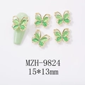 Macro view of gold bow-knot nail charms with green opal stone and tiny diamonds - Hollow Cat Eye Butterfly Gold Frame Style (9824)
