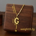 Golden titanium steel necklace with letter G pendant and tassel on a wooden stand - Letter G / Gold