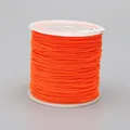 Macro detail of 0.8mm bright orange braided nylon cord on white spool for DIY jewelry crafts - Color F172 Neon Orange