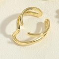 Makro-Detail des vergoldeten, gedrehten offenen Rings mit poliertem Metall-Finish - Doppelschichtige Wellenring