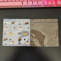 Detail of blue cartoon puppy pouch and solid brown foil packaging on wood surface - Puppy Pattern