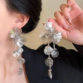Close-up of silver long tassel flower earrings with translucent petals on model - Glossy Flower Long Tassel Style / Silver