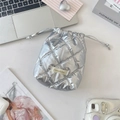 Macro detail of silver quilted PU leather drawstring pouch on a lifestyle desk setup - Diamond Grid Silver