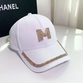 Detail shot of white cotton cap featuring a large golden M letter and colorful rhinestones - Letter M / White