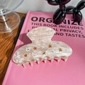 Detailed view of pink marble acetate hair claw clip with rhinestones and moon star charms - 9cm / Pink