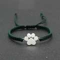 Detail view of a handmade green braided bracelet with a silver metal paw charm pendant - Dark Green