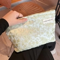 Green canvas makeup bag with floral embroidery and top handle held by a model - Embroidery Green