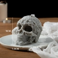 Candela profumata a forma di teschio grigio freddo con incisioni floreali decor - Grigio (Mora e Basilico)