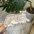 Handheld view of a leopard-shaped ceramic tray featuring brown spots on a beige surface - Lying White Circle Leopard