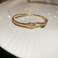 Macro detail of 18k gold plated snake head bracelet with green zircon eyes and scales - 20# Golden Snake Head Buckle (Real Gold Plated)