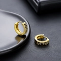 Détail macro de boucles d'oreilles créoles dorées serties de zircons noirs pavés - Or Noir Zircone