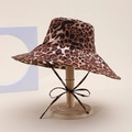 Classic leopard print wide-brim bucket hat with chin strap bow on wooden stand - Leopard Style / Brown