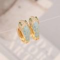 Macro detail of snake head earring with sky blue enamel and green gemstone eyes - Light Blue