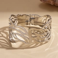 Detail eines silbernen Manschettenarmbands mit Durchbruchmuster und poliertem Finish - Silber