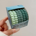 Detail von fünf Spiral-Haargummis in Feldgrün-Verlaufstönen und Box-Verpackung - 12# Grüne Serie