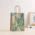 Detail of kraft paper gift bag with green tropical leaf prints and woven paper handles - 21*15*8cm / 704-2