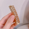 Amber spiral telephone wire hair tie with golden metal ends and resin texture - Basic Telephone Wire Hair Tie (1pc)
