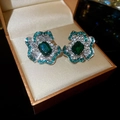 Detail view of flower earrings with emerald crystal and pavé diamonds in a gift box - Green (925 Sterling Silver Pin)
