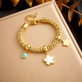 Detail eines vergoldeten Perlenarmbands mit weißem Klee und türkisfarbenen Anhängern - Blumen Mond Stern Stil (B1244)