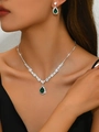 Detailed macro view of pear-cut green sapphire pendant necklace and matching earrings - 695 Green Necklace + Stud Earrings Set