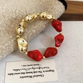 Close-up of vintage acrylic beaded bracelet with golden and red irregular stones - Bracelet / Red