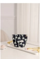 Detail der dunkelblauen Giraffen-Jacquard-Kosmetiktasche mit Blumenanhänger auf Tablett - Blaue Giraffe