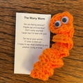 Handmade orange crochet worry worm with poem card for anxiety relief on wood surface - Orange Worm
