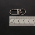 Macro view of 35mm gun black swivel lobster clasp with a scale for size reference - Gunmetal