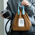 Brown drawstring lunch bag with light blue woven handle and inspirational square label - Tea Brown