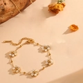 Gold chain bracelet featuring five white cat-eye stone flower charms with small gold beads - Gold White Cat's Eye Bracelet