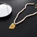 Baroque pearl necklace with gold relief portrait pendant on a matte black surface - 04-C5 Titanium Steel Natural Pearl Necklace Portrait Pendant