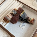 Dettaglio di un fermaglio per capelli con fiocco in velluto e tessuto tweed in un portagioie - Clip a Torsione / Taglia unica / Marrone