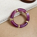 Detail view of purple marble resin segments joined by polished gold metal ring buckles - Round Splicing / Purple