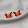 Macro shot of red butterfly earrings with gold metal frame on grey silk fabric background - Red Gradient Butterfly Studs