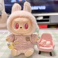 Plush doll in pink knitted sweater and rabbit ear hood sitting on a miniature pink chair - Pink Smiley Face Brooch / First And Second Generation Keychains Are Compatible With La Cloth Dolls. Dolls Not Included.