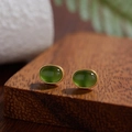 Macro shot of oval green jasper stud earrings with gold plating on a natural wood block - Natural Jasper Oval Gold 5*7mm