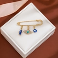 Detailed view of evil eye brooch with fish charm and blue rhinestones on jewelry box - Fish Pendant Style (Z252-1)