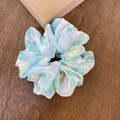 Elegante geplooide scrunchie met pastel aquarelpatroon op houten achtergrond - Groen